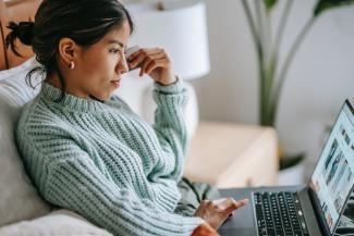 Focused young woman shopping online on her laptop